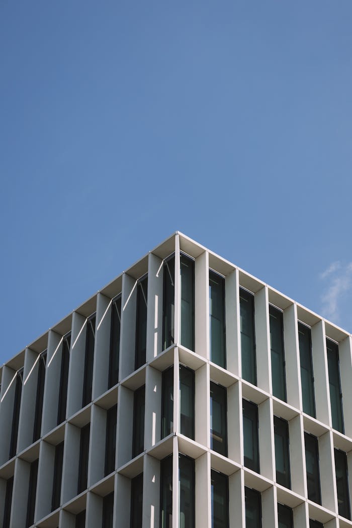 Low-angle view of a modern office building in London with a clear blue sky backdrop.